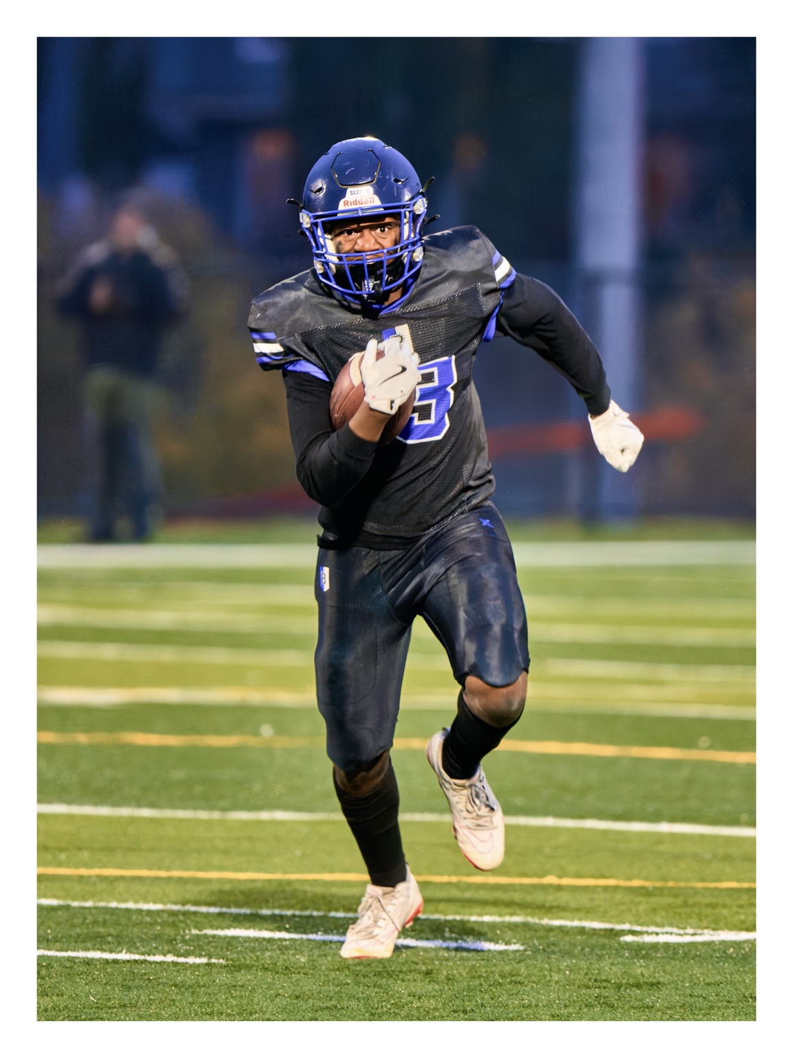 Football player carrying the ball downfield in a black and blue uniform