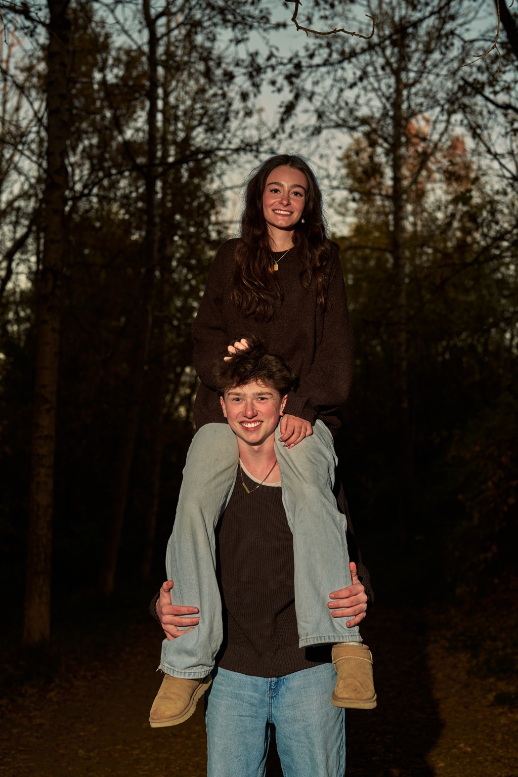 A couple posing together in the woods