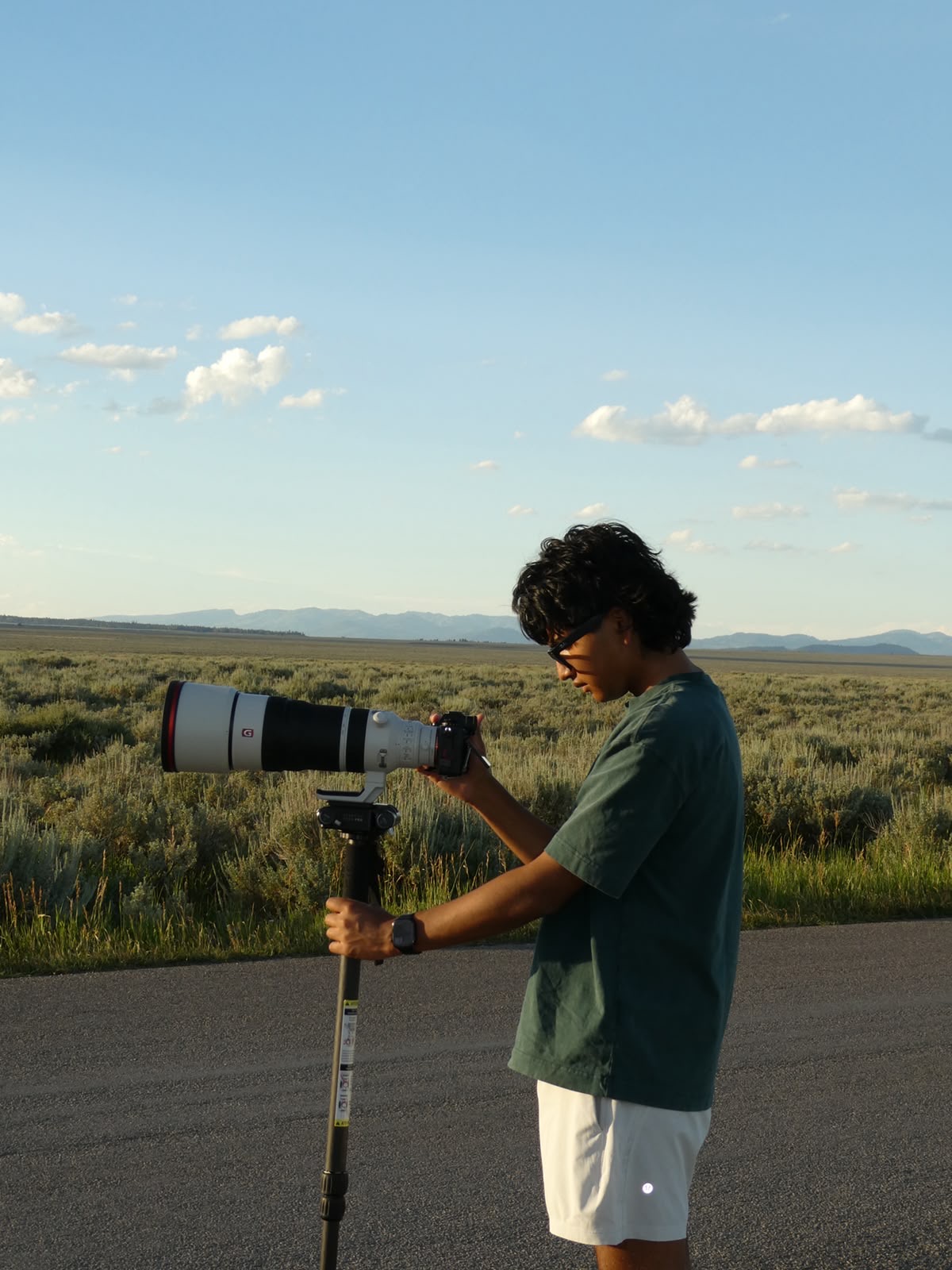 Dutt Vyas adjusting his camera and telephoto lens on a monopod outdoors