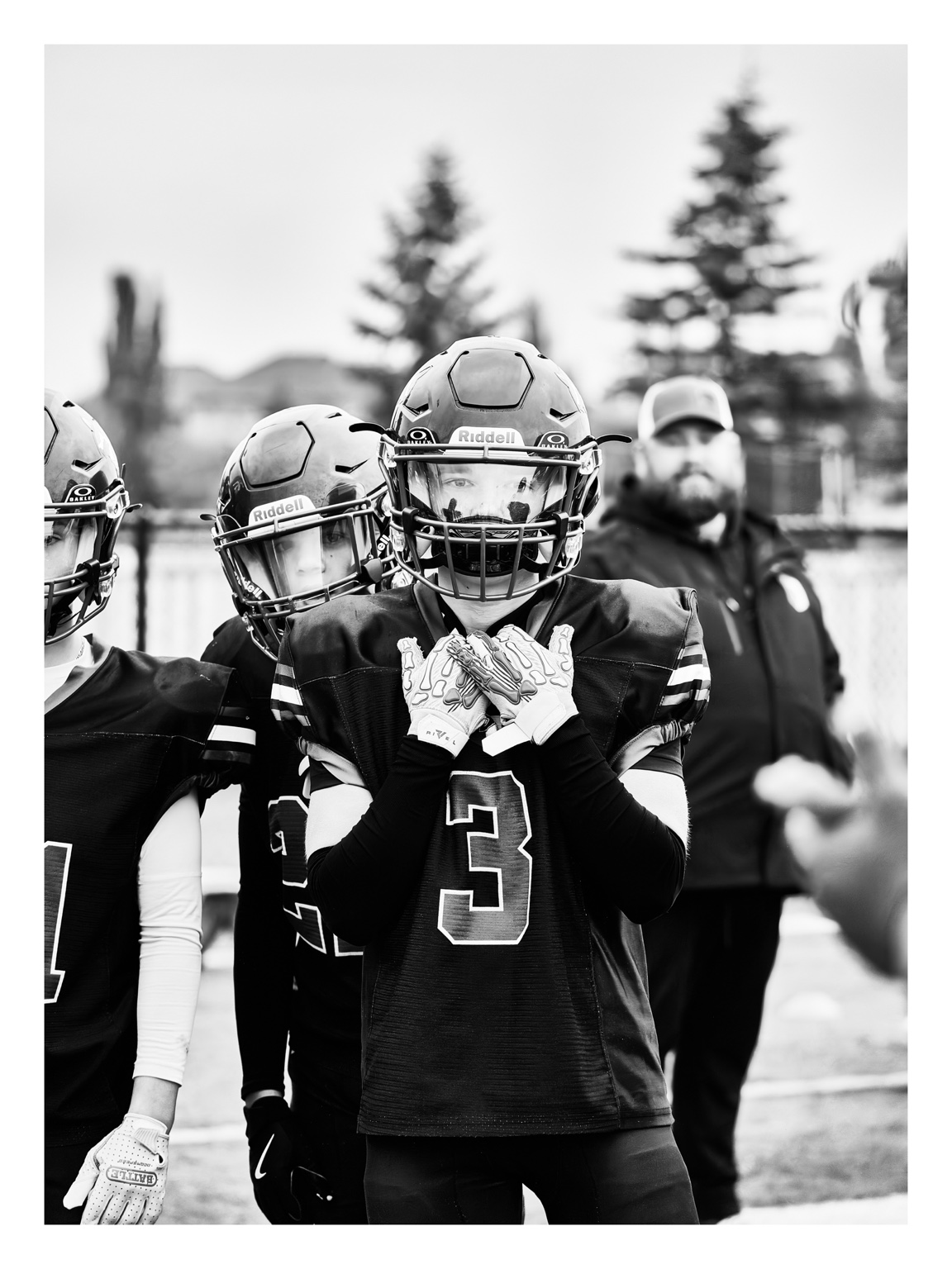 Black and white portrait of a football player adjusting his gloves before the game