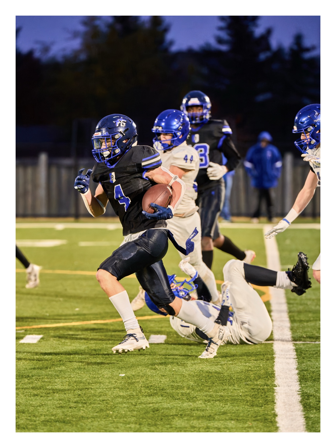 Football players running downfield during a play