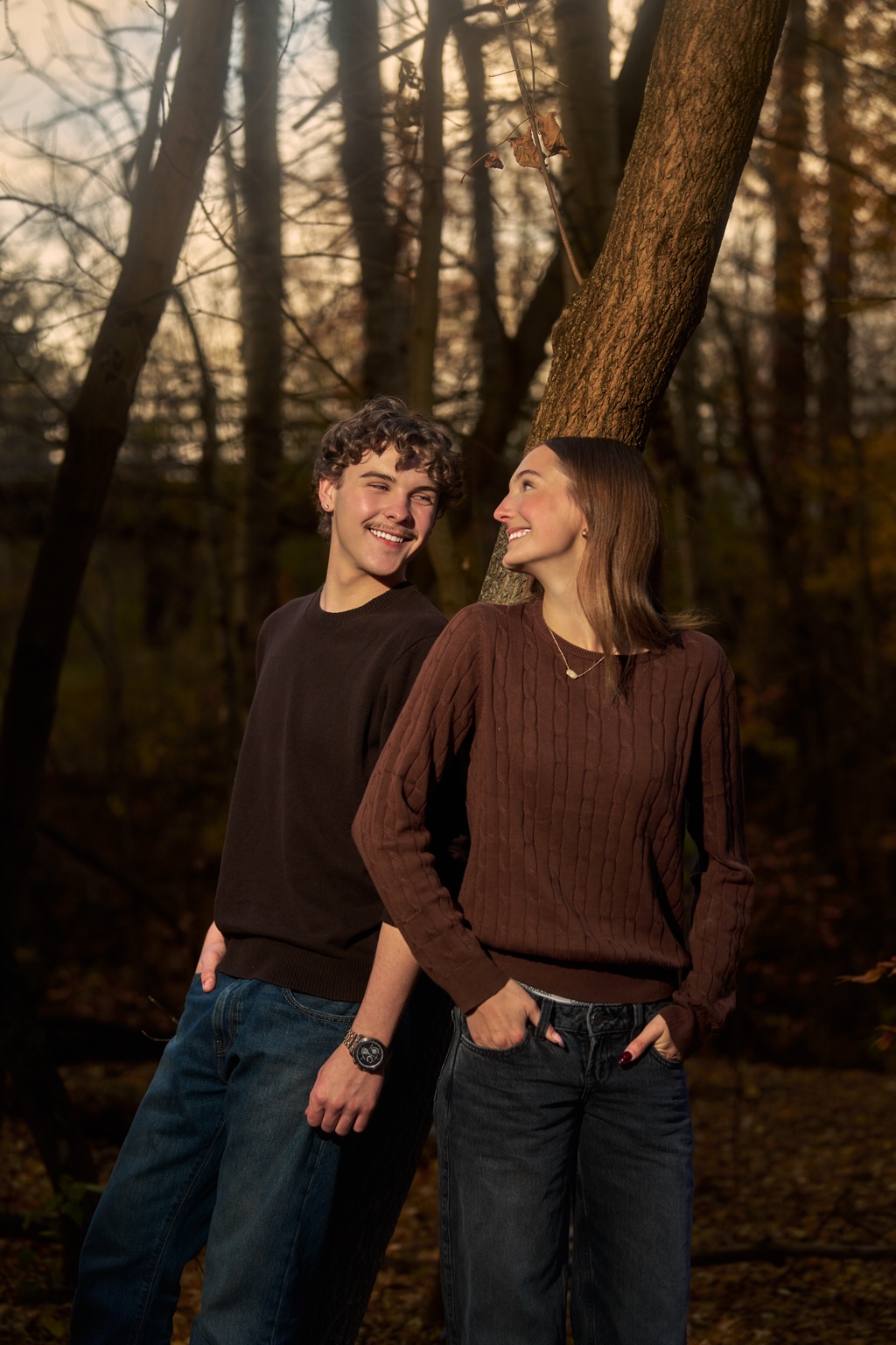 A couple smiling together beside a tree