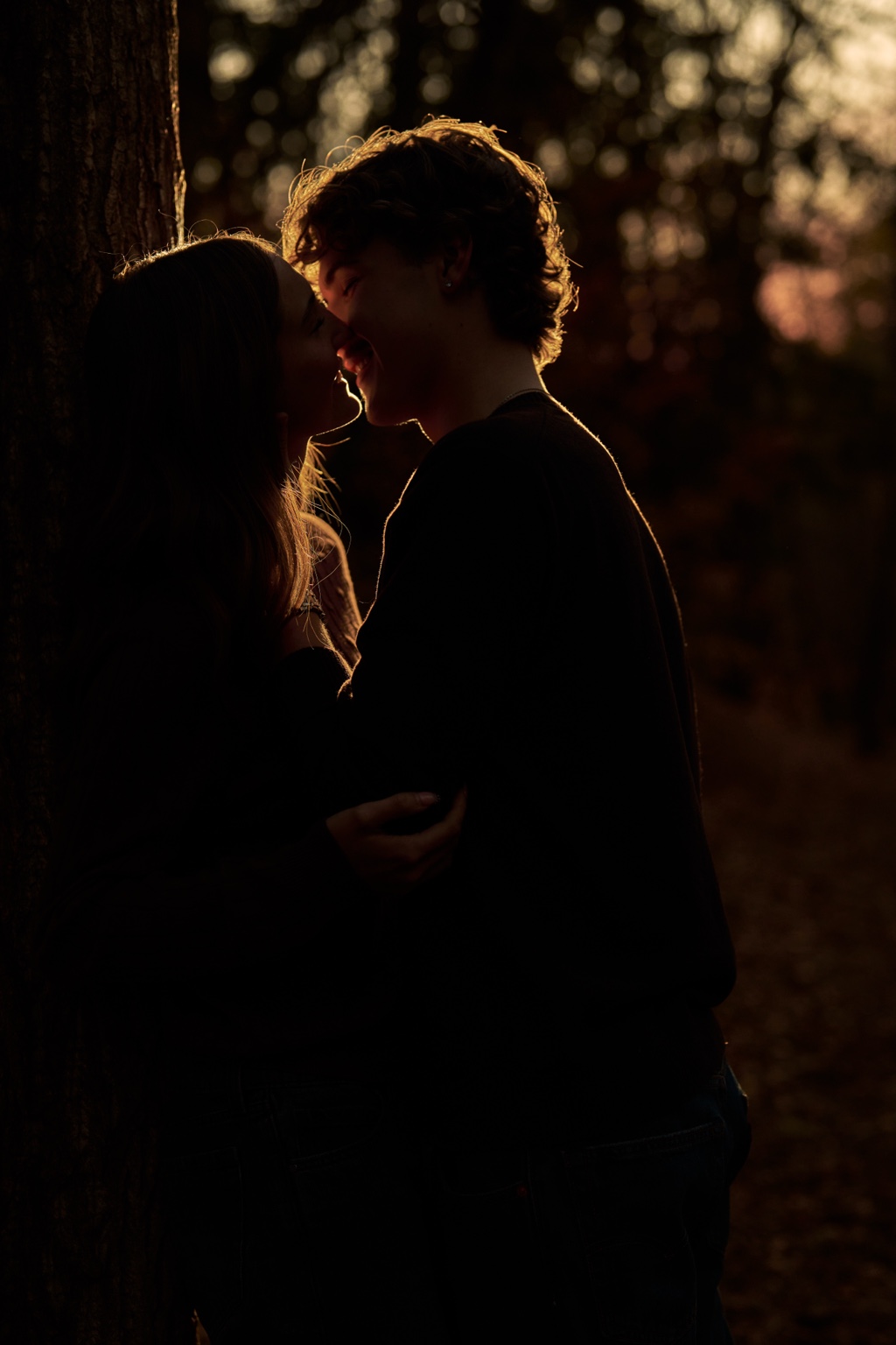 A couple together beside a tree in evening light