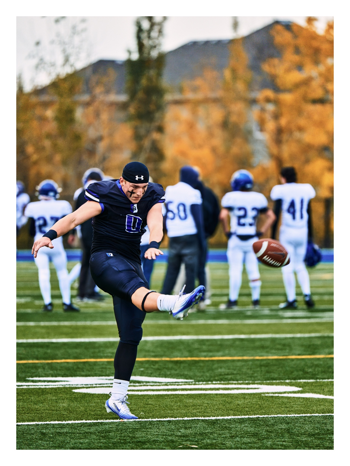 Football kicker striking the ball on the field